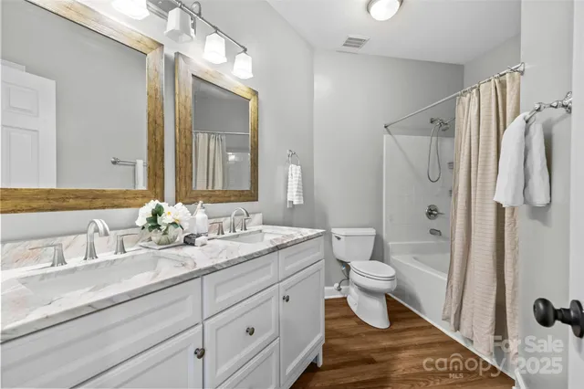 a bathroom with a double vanity sink toilet and shower