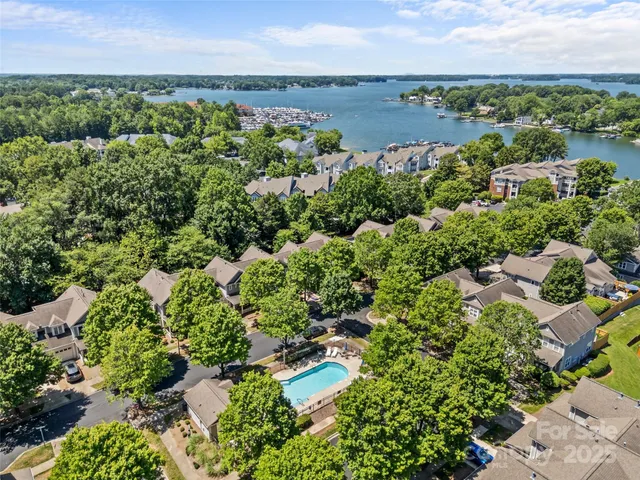an aerial view of a houses with a yard and lake view