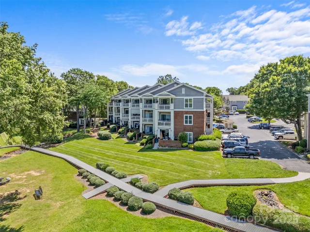 a view of a big house with a big yard and potted plants