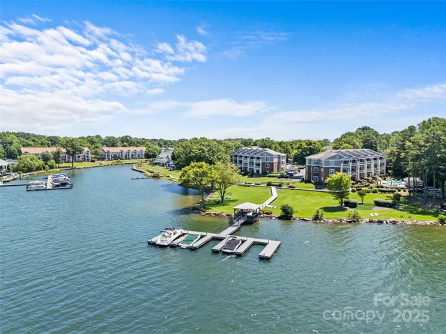 a view of a lake with lawn chairs and a big yard