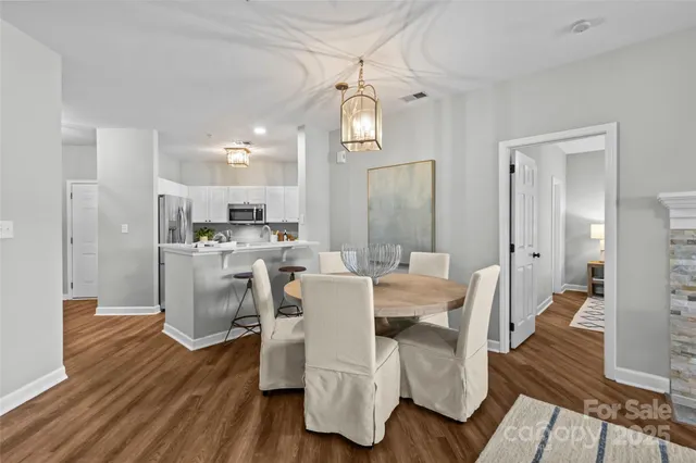 a view of a dining room with furniture a chandelier and wooden floor