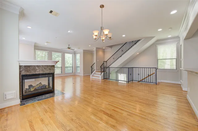 a view of a kitchen and an empty room with wooden floor