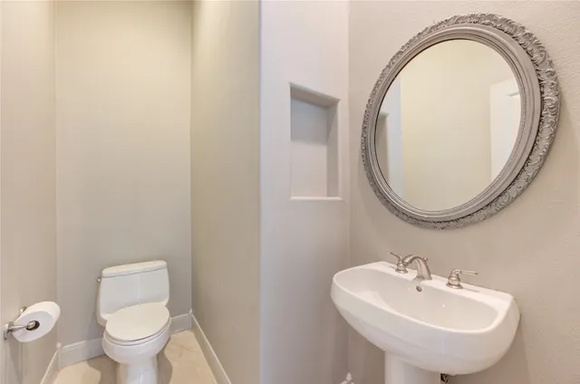 a bathroom with a sink a toilet and a mirror