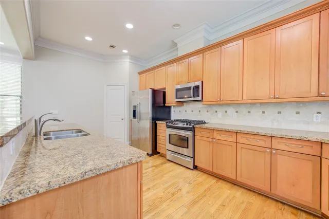 a kitchen with granite countertop a sink stove and cabinets