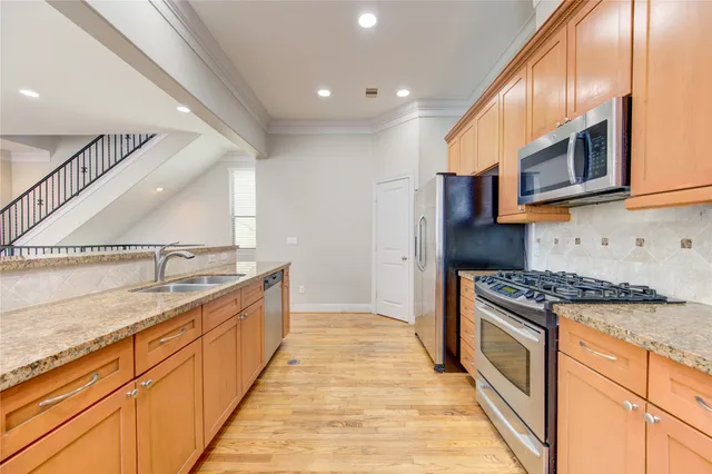 a large kitchen with stainless steel appliances granite countertop a stove and a sink