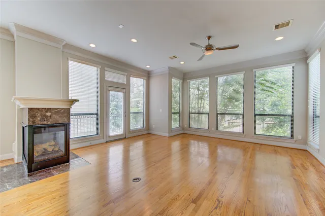 a view of an empty room with a window and wooden floor