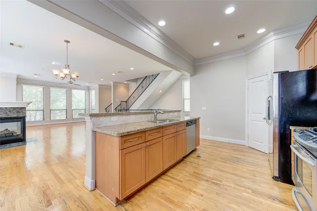 a kitchen with stainless steel appliances granite countertop a sink a stove and a wooden floors