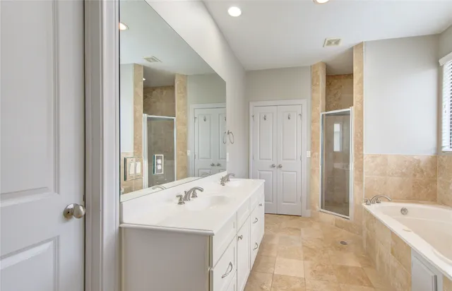a bathroom with a tub sink and mirror