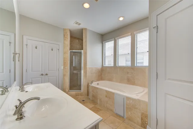 a spacious bathroom with a tub sink and mirror