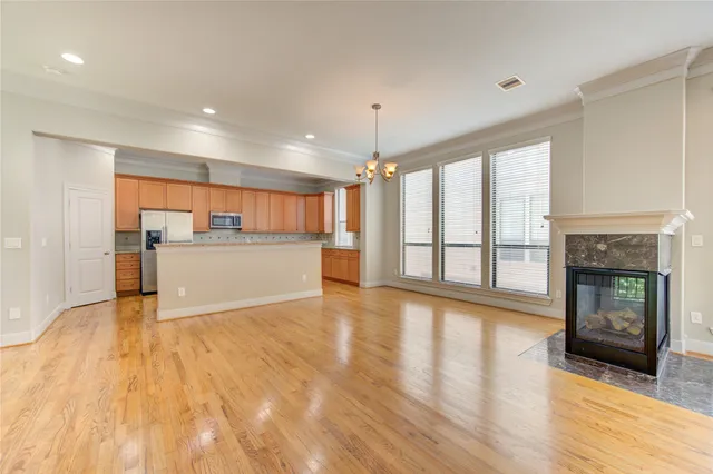 a view of a big room with wooden floor and a kitchen
