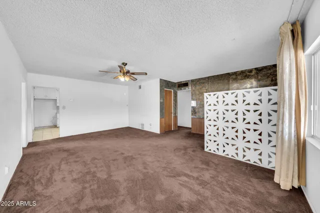 a view of a livingroom with a ceiling fan and entryway