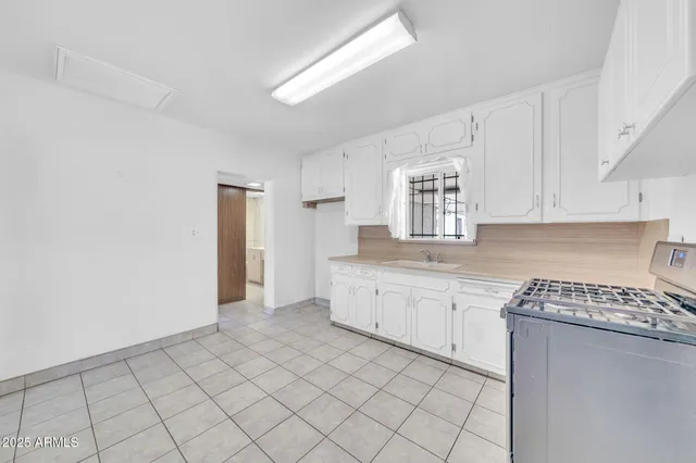 a kitchen with granite countertop white cabinets and white appliances