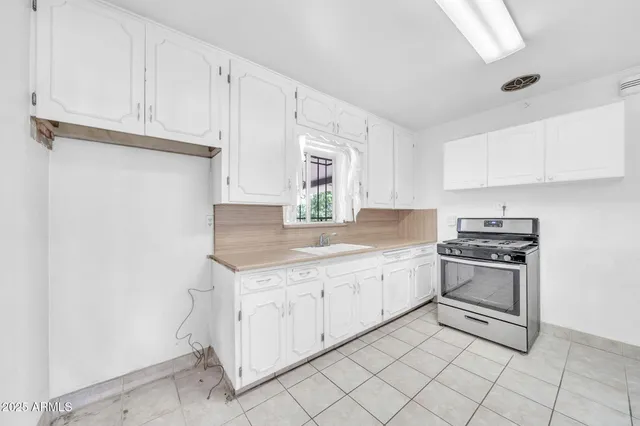 a kitchen with granite countertop white cabinets and white appliances