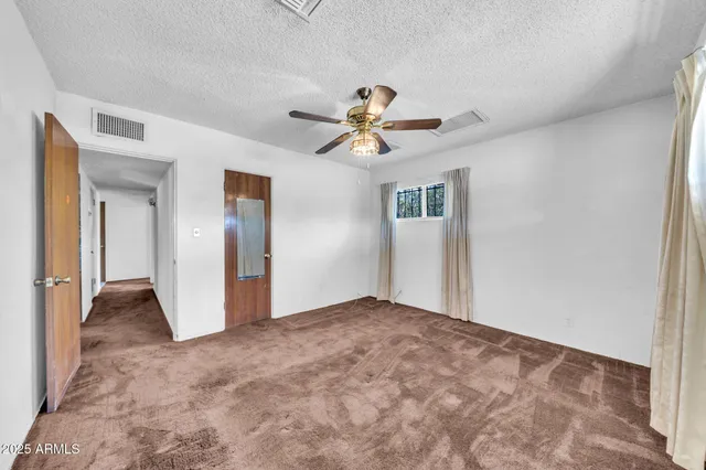 a view of a big room with closet and a chandelier fan