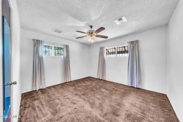 a view of a livingroom with a ceiling fan and window