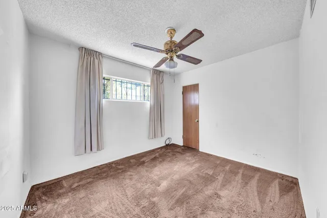 a view of a livingroom with a ceiling fan and window