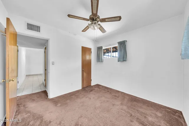 a view of a livingroom with a ceiling fan and window