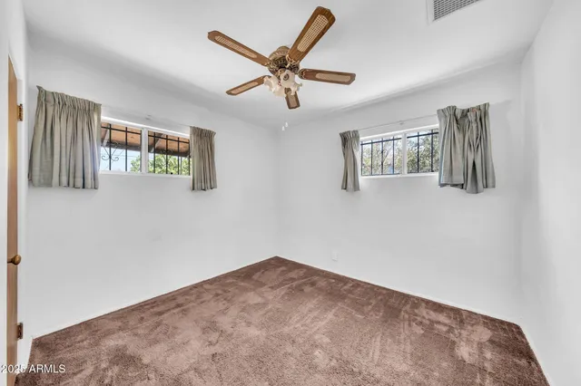 a view of empty room with ceiling fan
