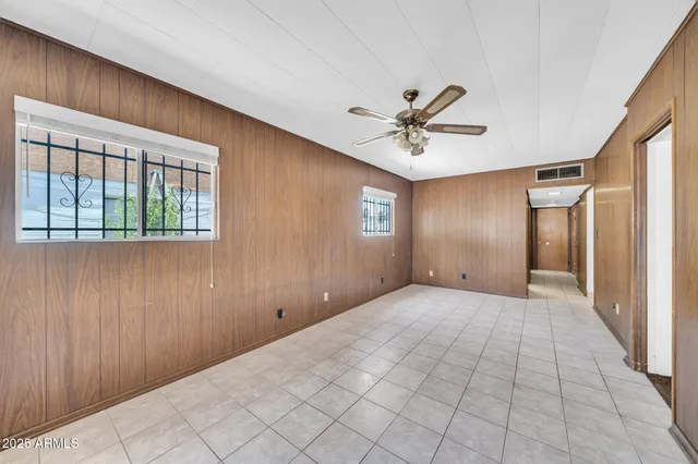 a view of an empty room with a chandelier fan