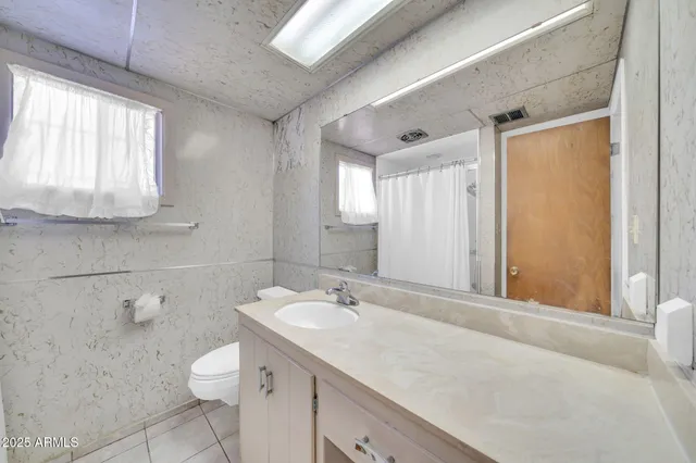 a bathroom with a sink a toilet and a window