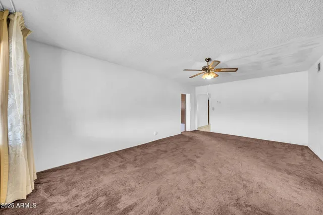 a view of a livingroom with a ceiling fan and window
