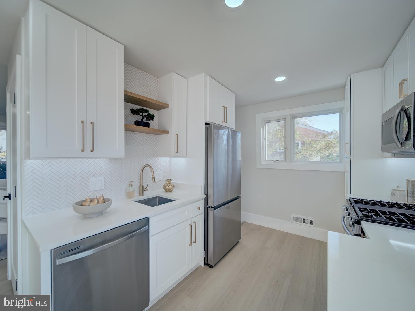 2906 Radius Road Silver Spring, MD 20902 - Photo 11 of 43 a kitchen with stainless steel appliances a refrigerator sink and microwave