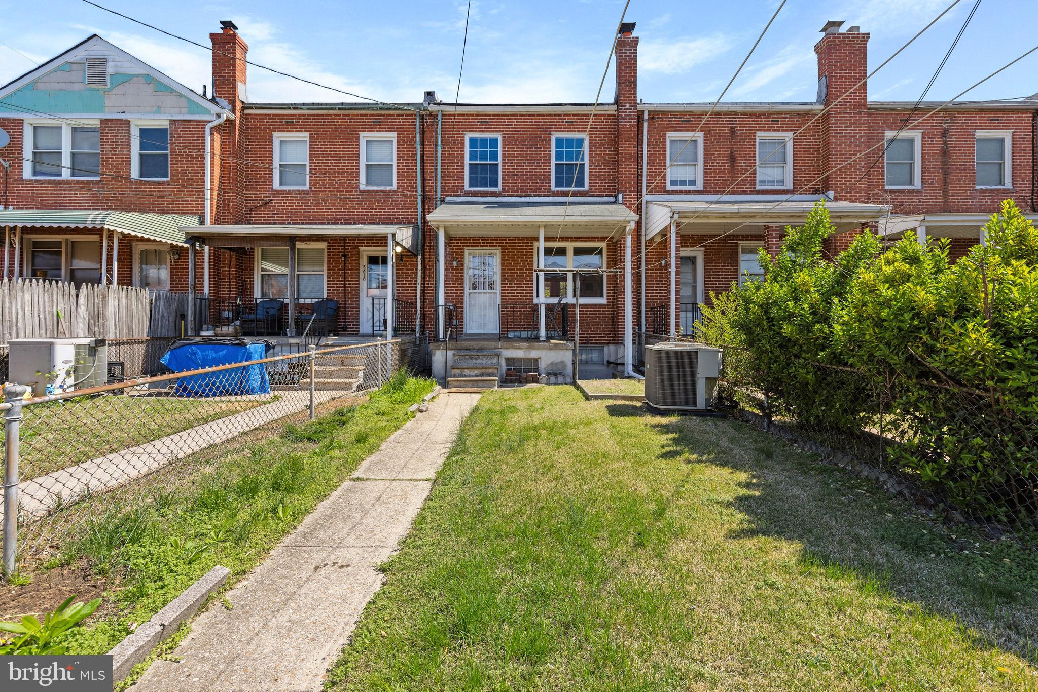 3418 Dunran Road Baltimore, MD 21222 - Photo 1 of 19 a front view of a brick building with a yard table and chairs