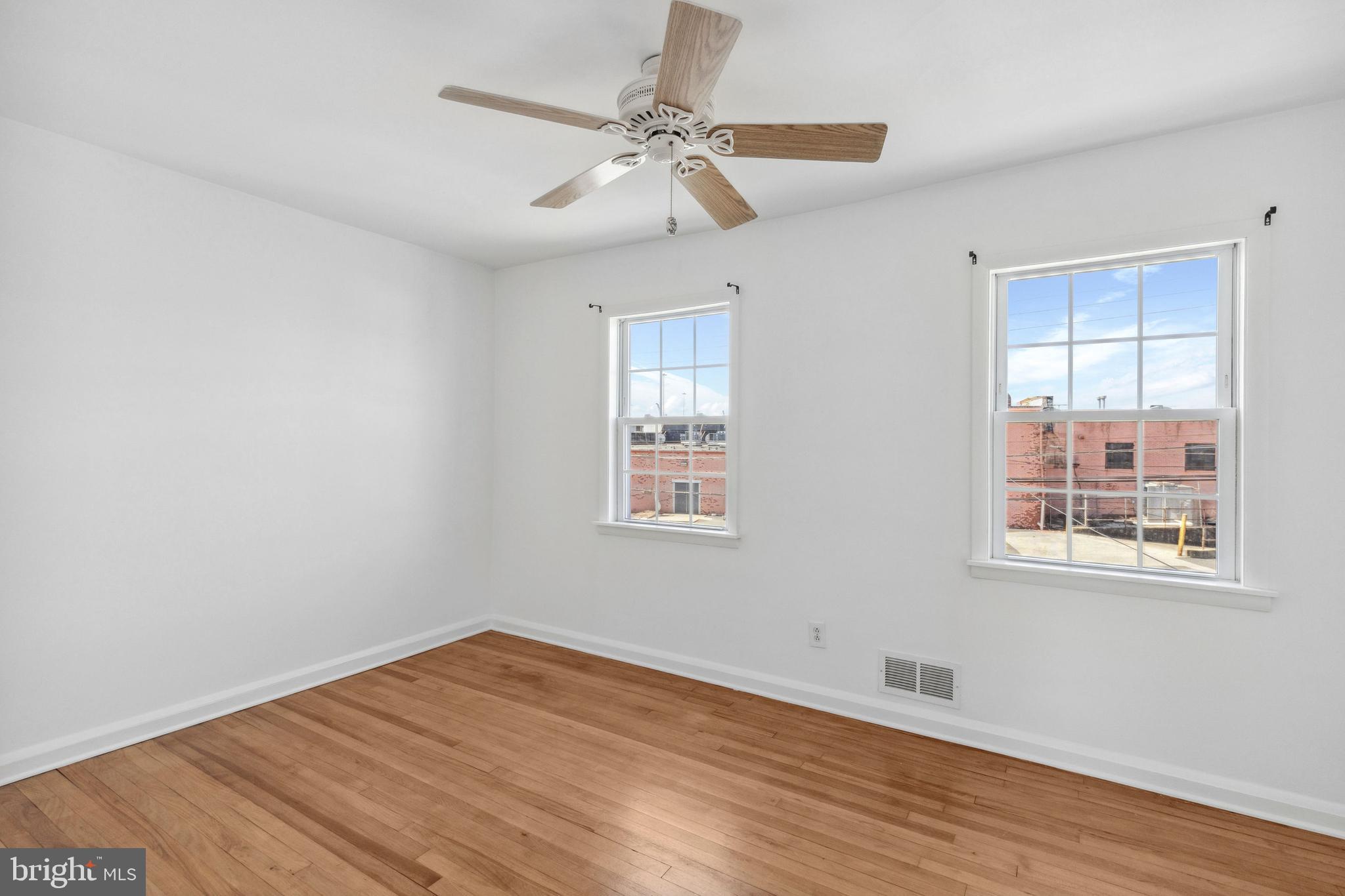 3418 Dunran Road Baltimore, MD 21222 - Photo 11 of 19 a view of an empty room with wooden floor and a window