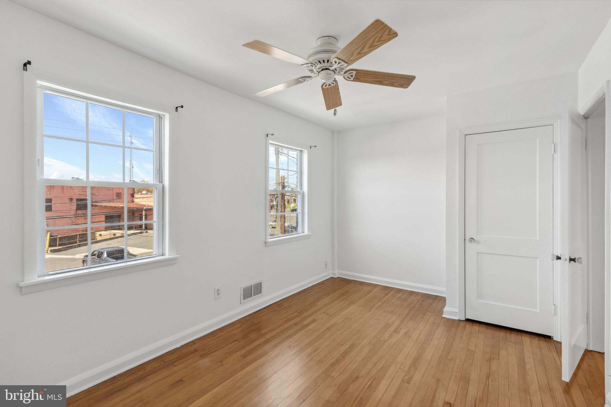 3418 Dunran Road Baltimore, MD 21222 - Photo 12 of 19 a view of an empty room with wooden floor and a window