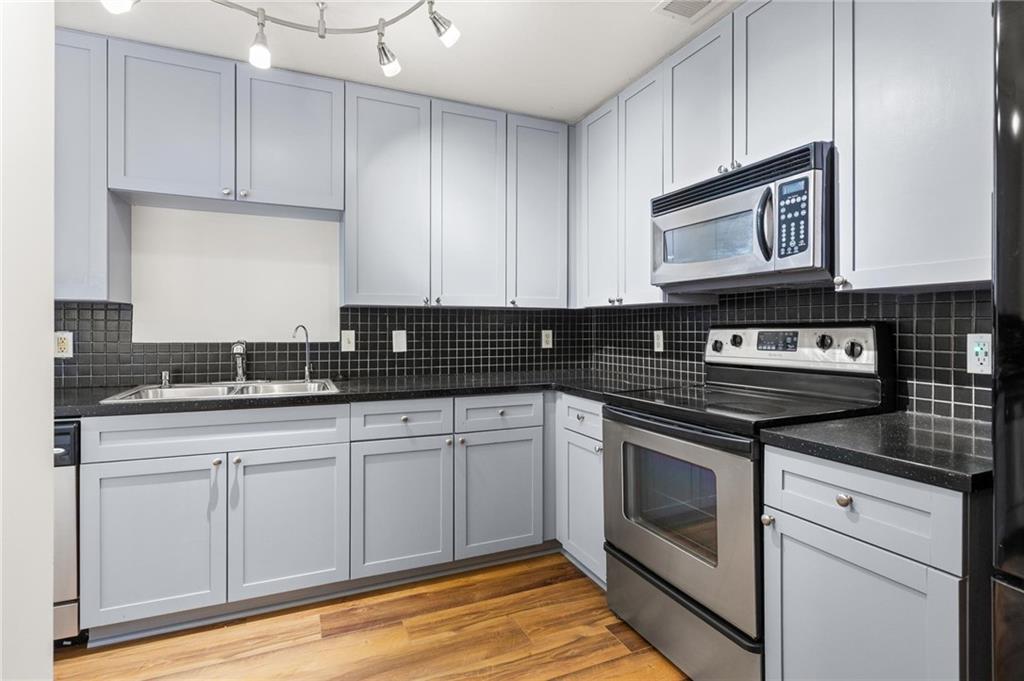 230 East Ponce De Leon Avenue, Unit 104 Decatur, GA 30030 - Photo 12 of 27 a kitchen with granite countertop cabinets stainless steel appliances and a sink