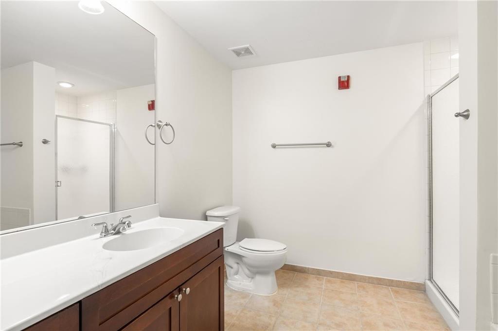 230 East Ponce De Leon Avenue, Unit 104 Decatur, GA 30030 - Photo 21 of 27 a bathroom with a granite countertop sink a toilet and a mirror