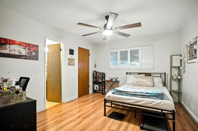 a bedroom with a bed and wooden floor
