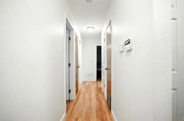a view of a hallway with wooden floor