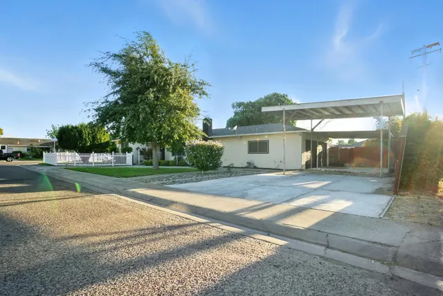 a view of a house with backyard and a tree