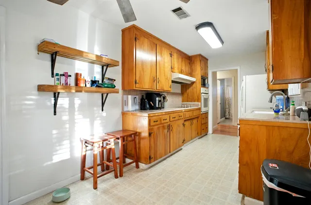 a kitchen with stainless steel appliances kitchen island granite countertop a refrigerator and a stove top oven