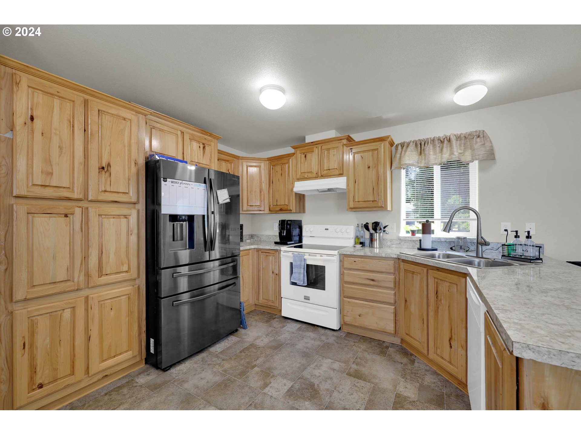 92030 Marcola Road Springfield, OR 97478 - Photo 27 of 31 a kitchen with granite countertop a refrigerator oven a sink dishwasher and white cabinets with wooden floor