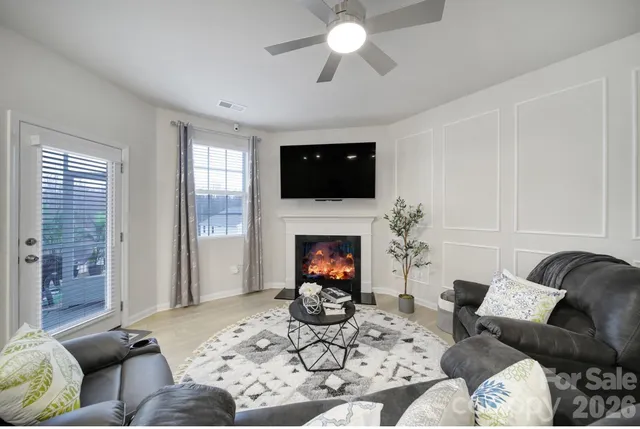 a living room with furniture a fireplace and a flat screen tv