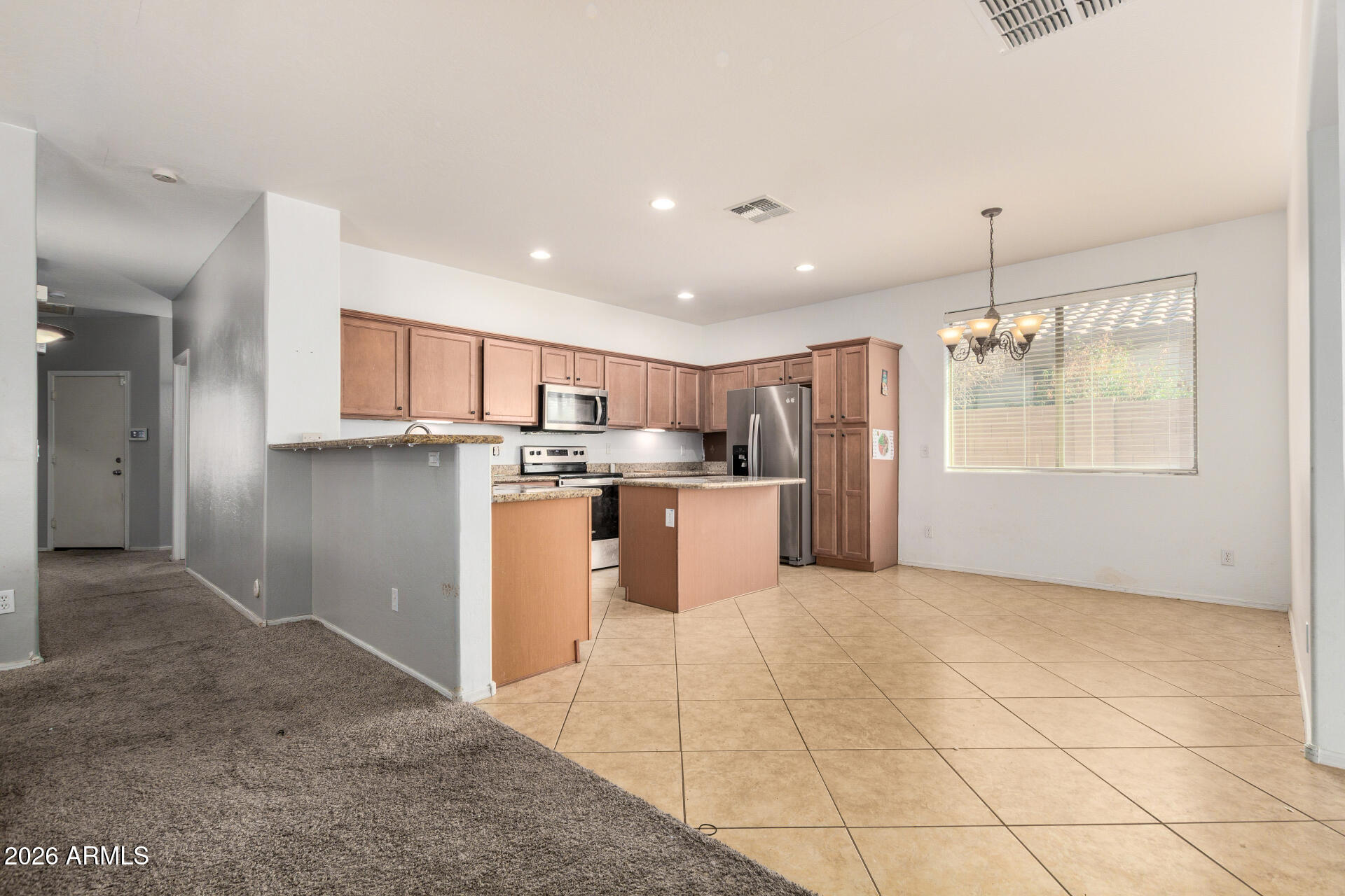 15339 West Jackson Street Goodyear, AZ 85338 - Photo 10 of 36 a kitchen with stainless steel appliances kitchen island granite countertop a refrigerator and microwave