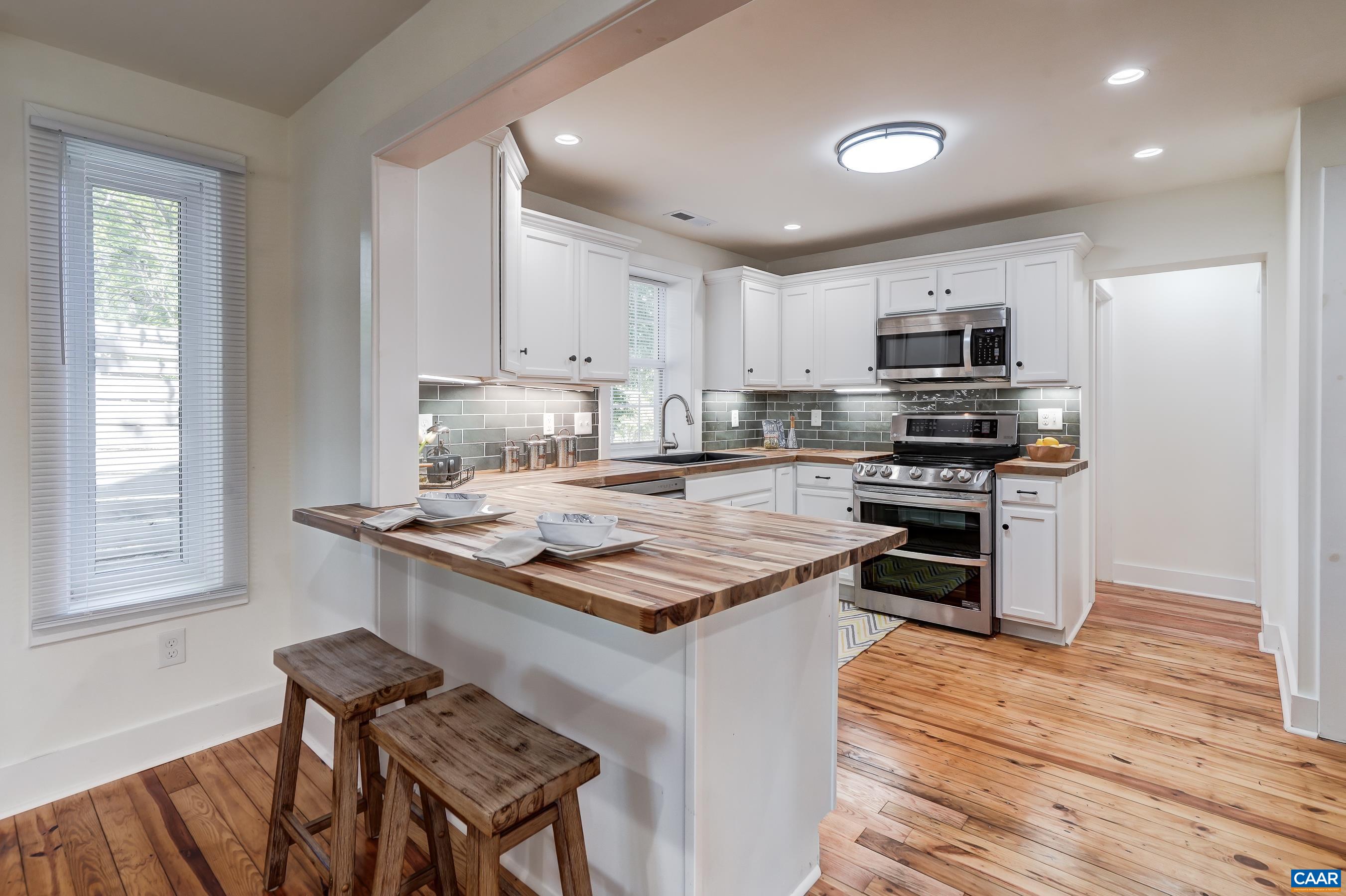 1407 Florence Road Charlottesville, VA 22902 - Photo 10 of 37 a kitchen with kitchen island granite countertop a stove top oven a sink dishwasher a dining table and chairs with wooden floor