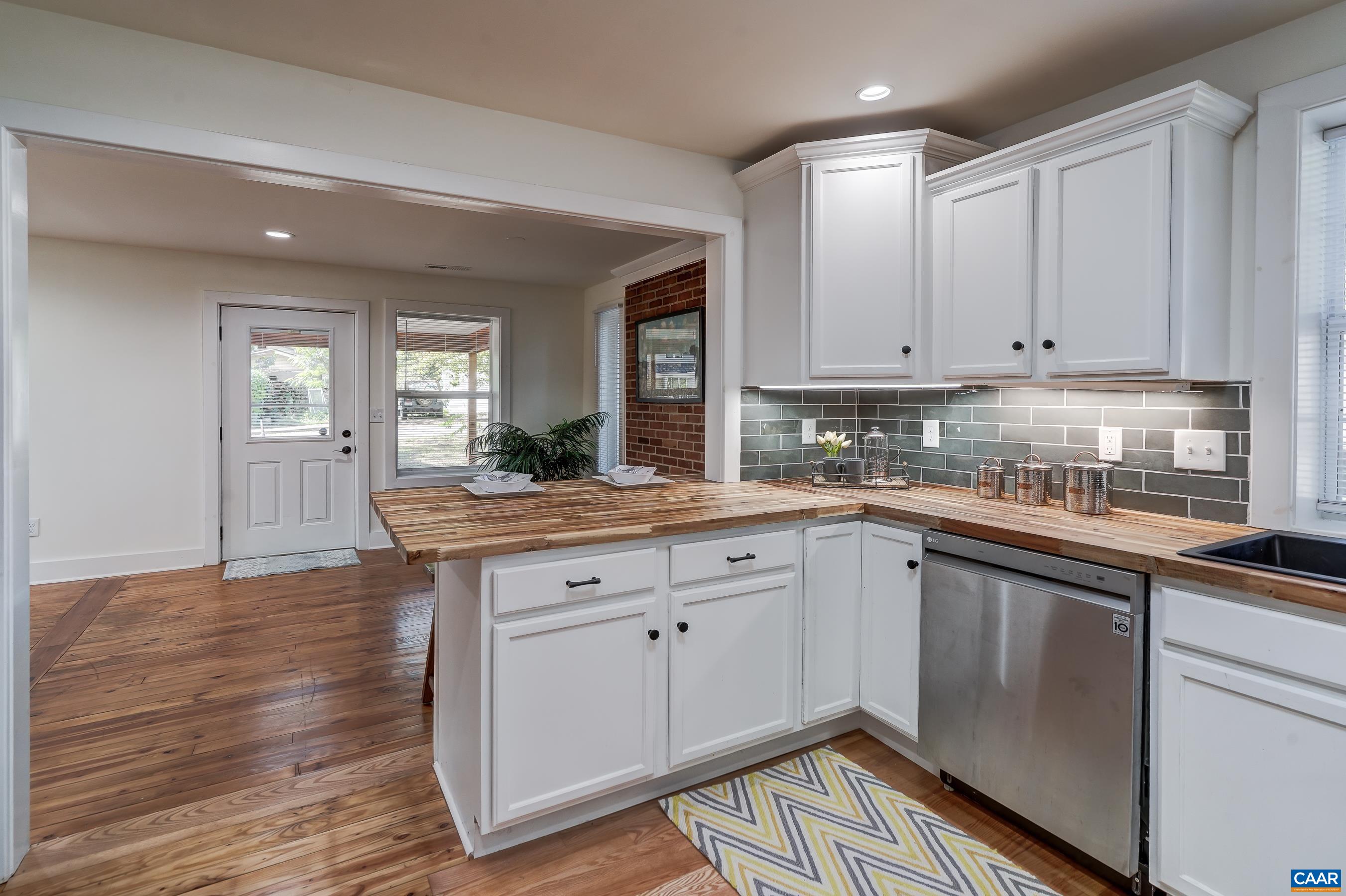 1407 Florence Road Charlottesville, VA 22902 - Photo 13 of 37 a kitchen with granite countertop wooden floors and white cabinets