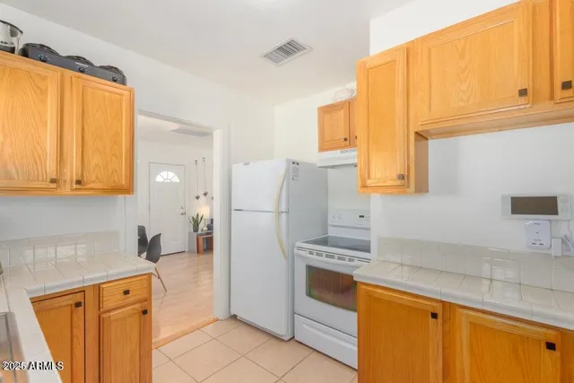 a kitchen with stainless steel appliances granite countertop a refrigerator and a stove