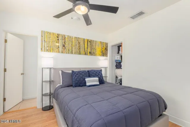 a bedroom with a bed and painting on the wall