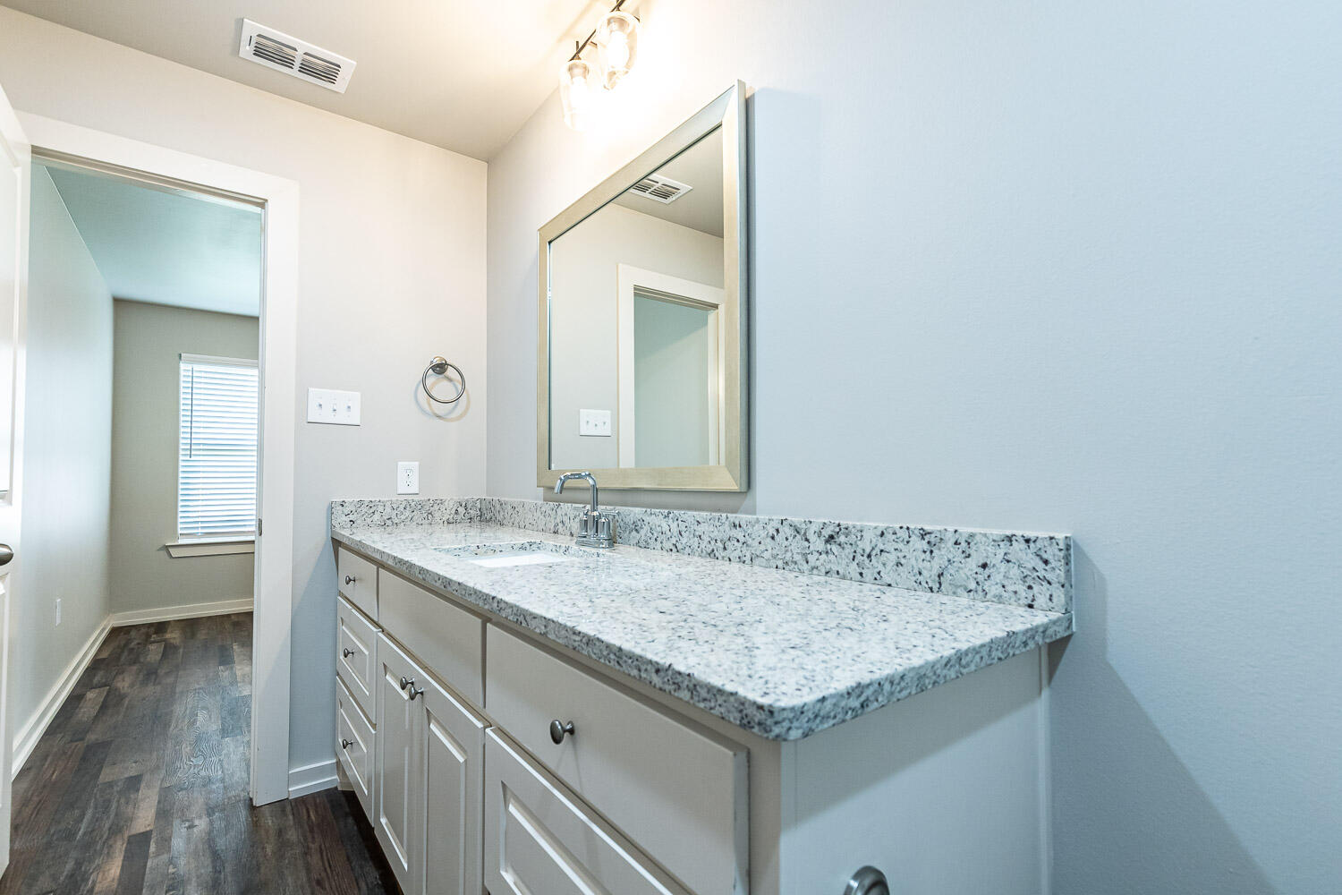 5522 122nd Street Lubbock, TX 79424 - Photo 18 of 23 a bathroom with a granite countertop sink and a mirror