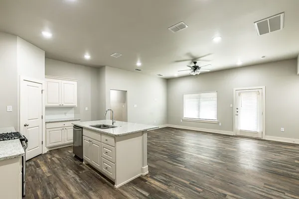 a kitchen with stainless steel appliances granite countertop a sink stove and wooden floor