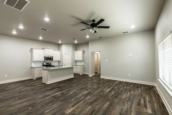 a large kitchen with stainless steel appliances a large counter top a stove a sink dishwasher and a refrigerator