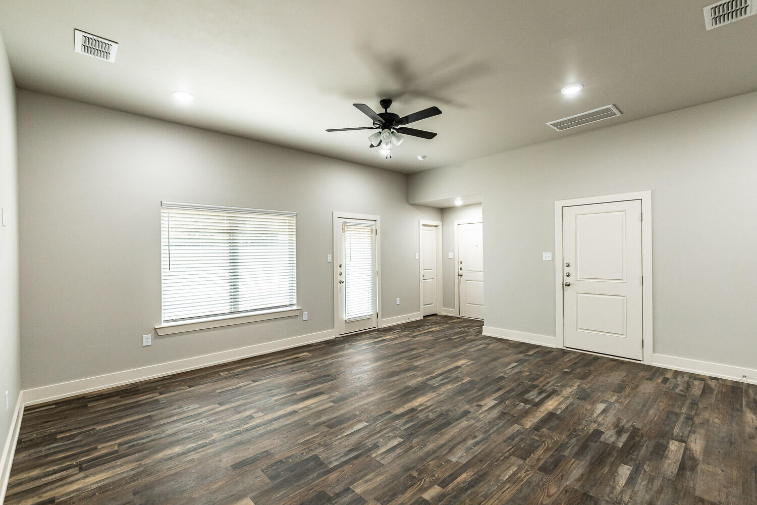5522 122nd Street Lubbock, TX 79424 - Photo 7 of 23 an empty room with wooden floor ceiling fan and windows