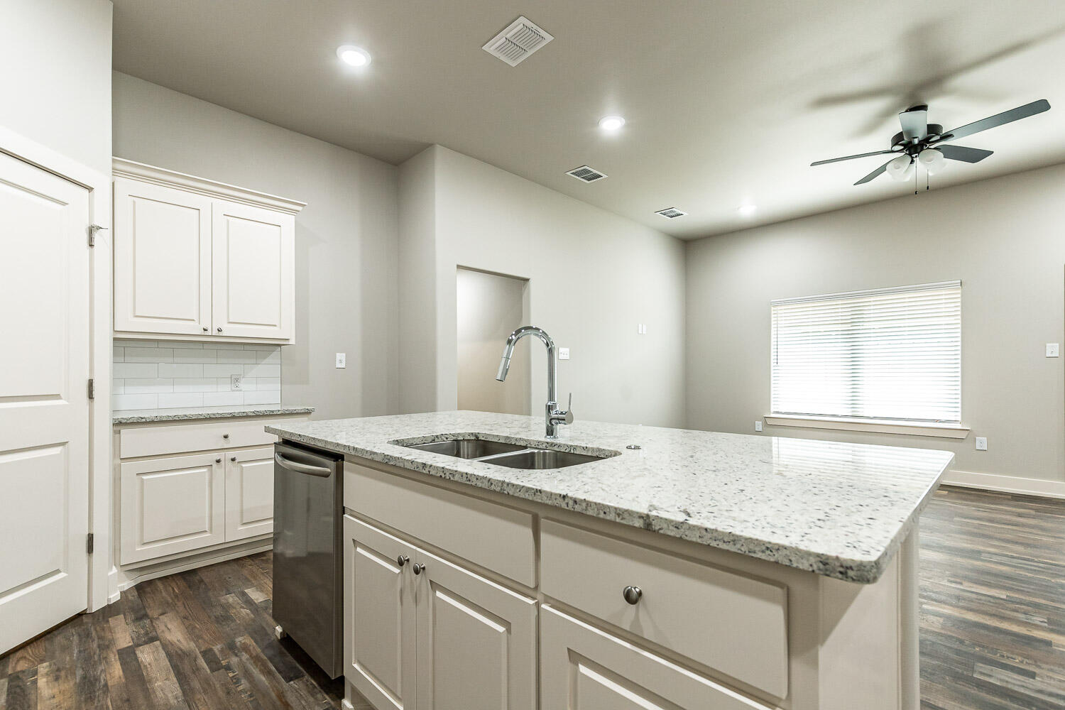 5522 122nd Street Lubbock, TX 79424 - Photo 8 of 23 a kitchen with kitchen island granite countertop a sink cabinets and wooden floor