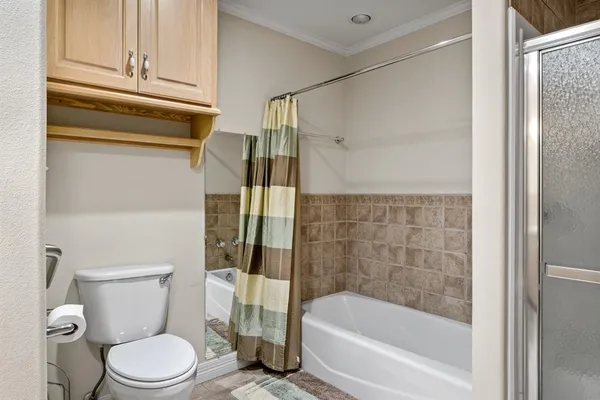 a white toilet sitting next to a bathtub