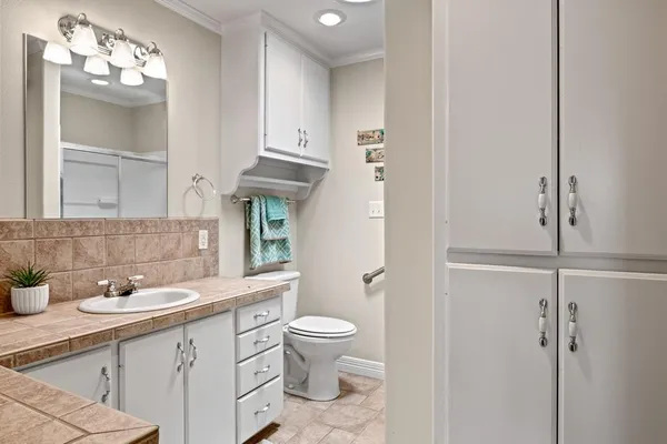 a bathroom with a sink a toilet and a mirror