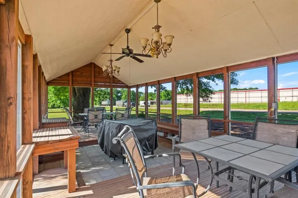 a view of a patio with table and chairs potted plants and floor to ceiling window